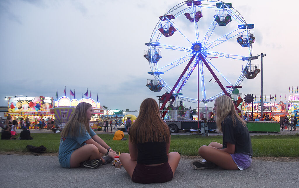 Terry Schrock, Megan Bowers, and Reese Ihler enjoy a conversation while eating fair food